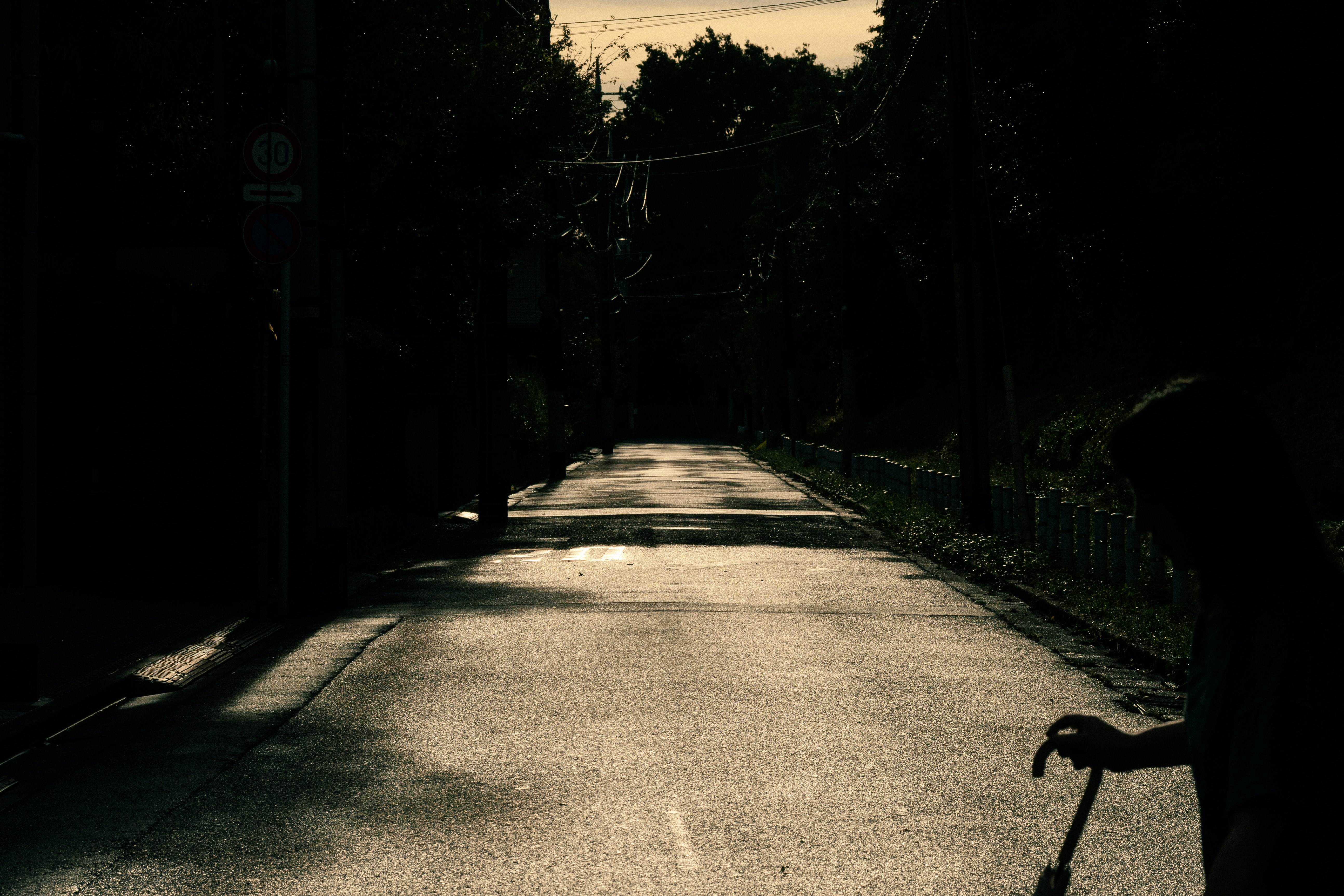 夕日に照らされた雨上がりの静かな路地の坂道