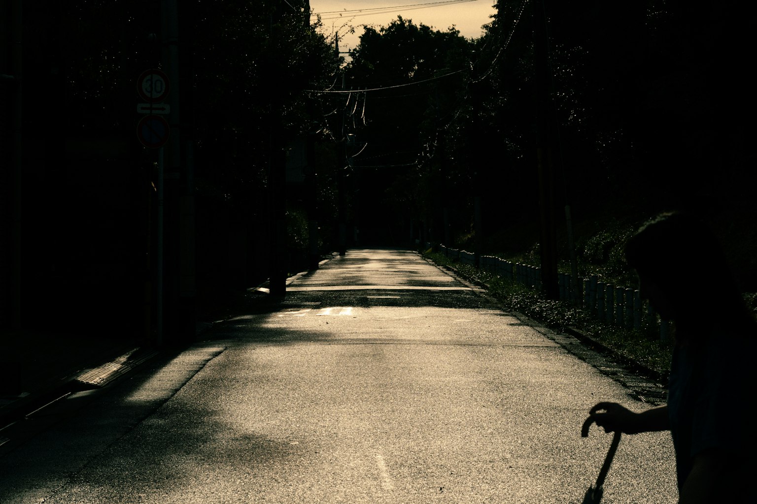 薄暗い通りを歩く人影と静かな風景