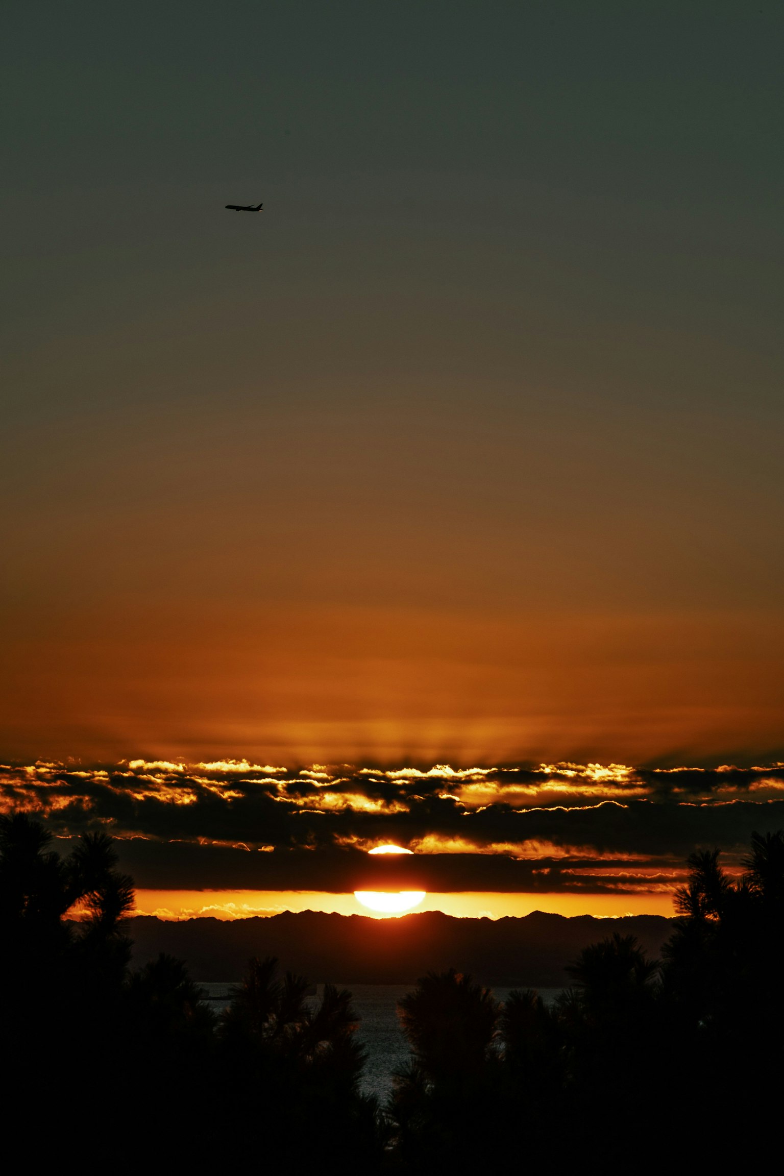 Paysage magnifique avec le coucher de soleil visible à travers les nuages avion volant dans le ciel