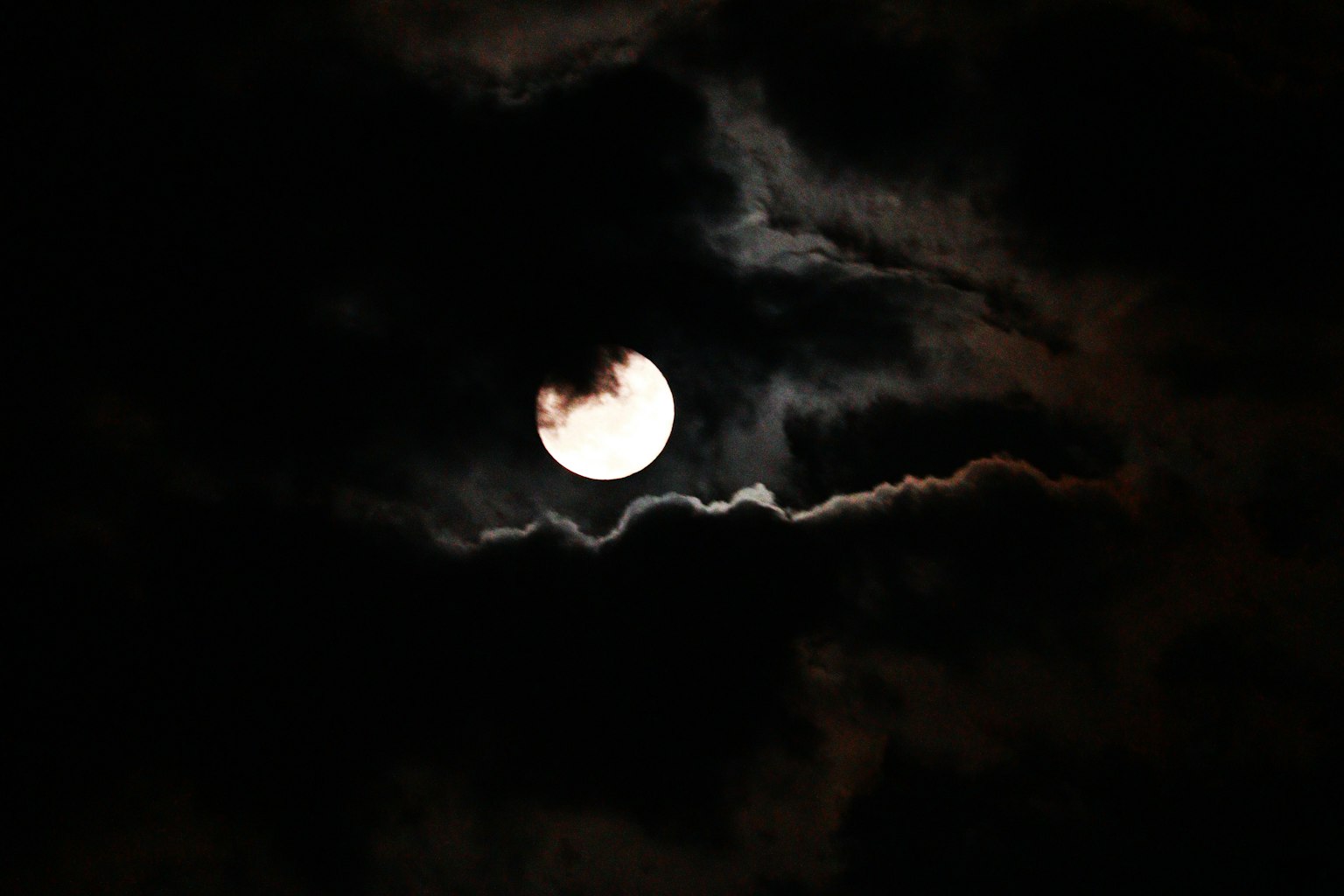 Luna brillante che splende tra le nuvole scure nel cielo notturno