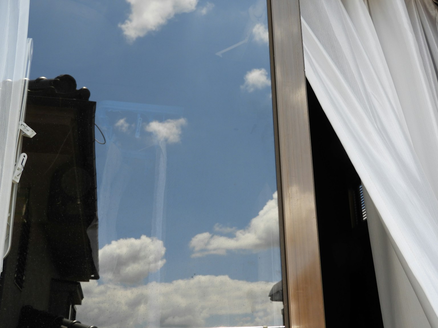 Phản chiếu bầu trời xanh và mây trong cửa sổ