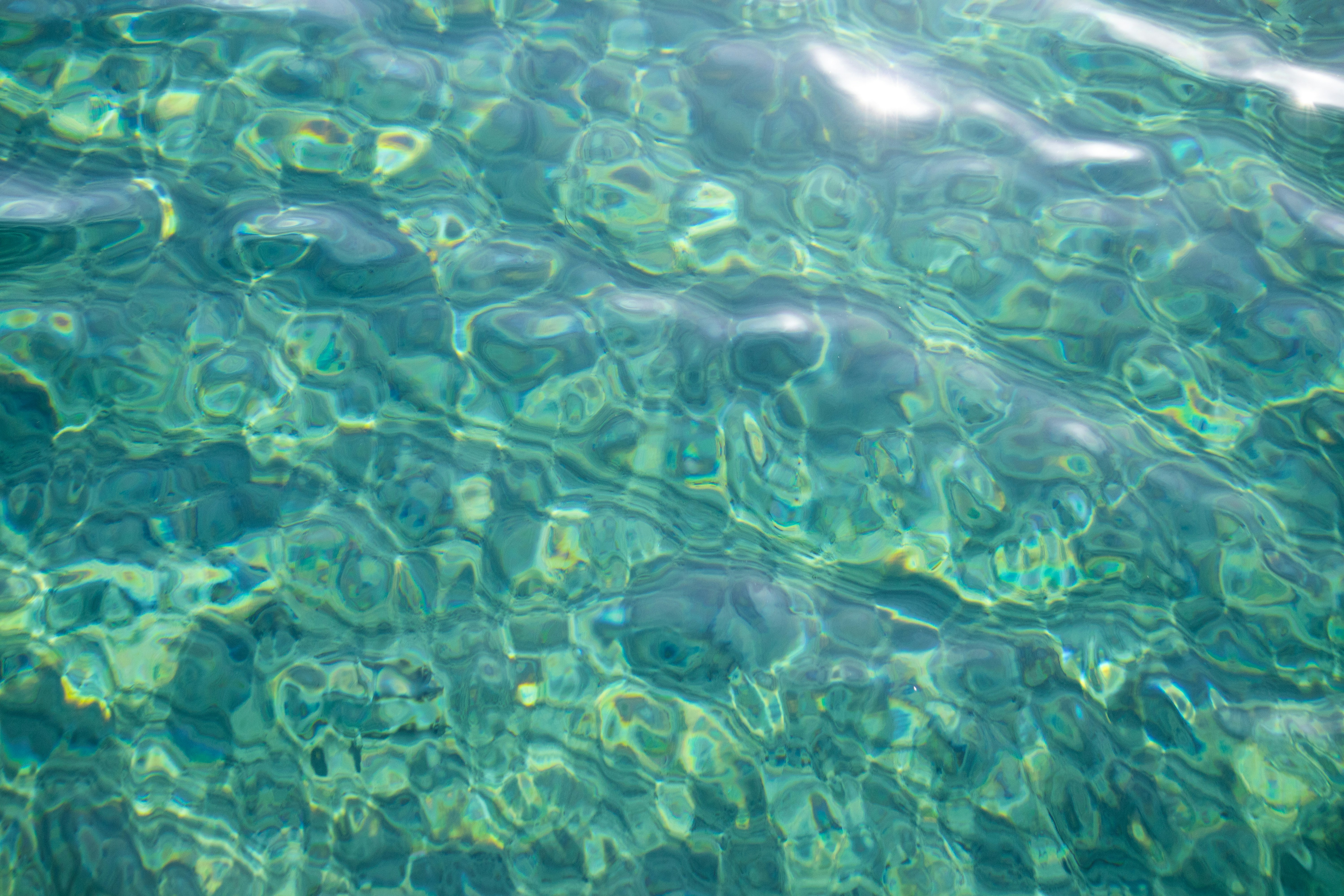 Acqua di mare limpida con onde e rifrazione della luce
