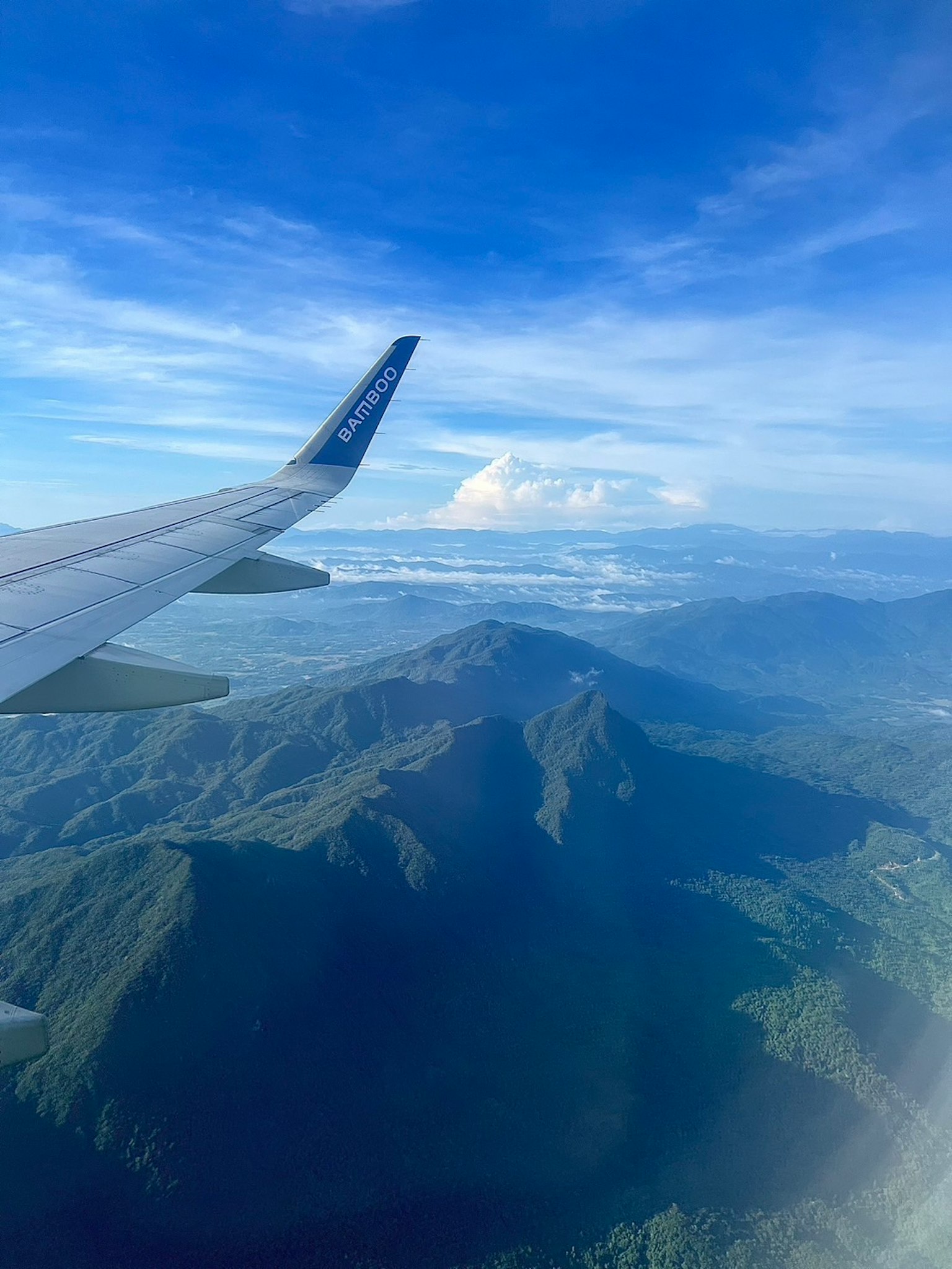 Vista dall'ala di un aereo che mostra montagne e cielo blu