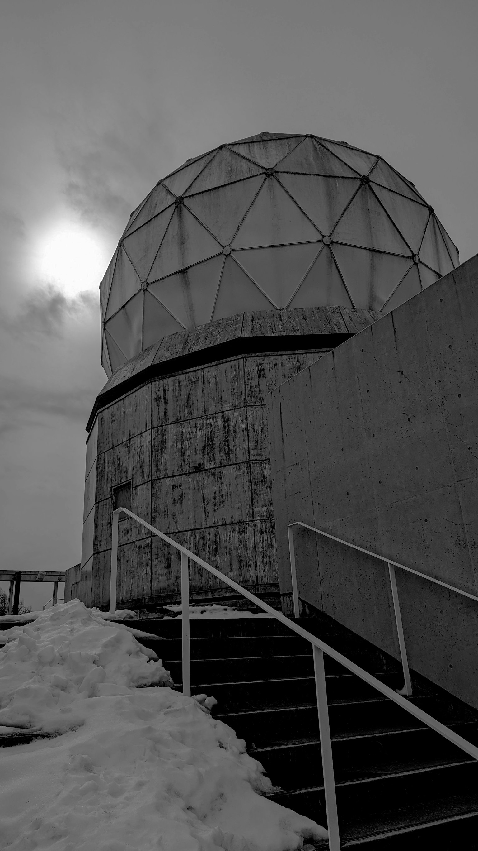 Scale innevate che portano a una struttura a cupola geodetica