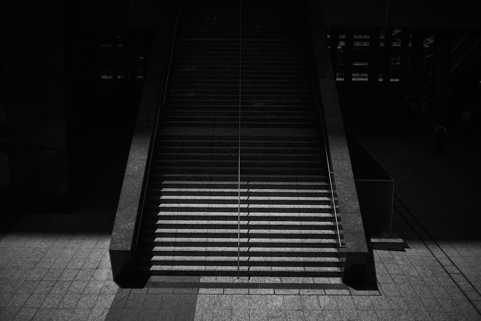 Immagine in bianco e nero di scale con un forte contrasto tra ombra e luce