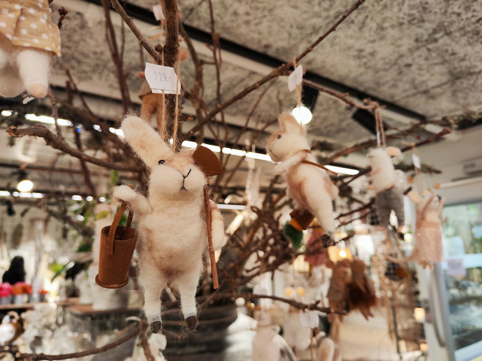 การตกแต่งกระต่ายน่ารักแขวนจากกิ่งไม้ด้วยพื้นหลังธรรมชาติ