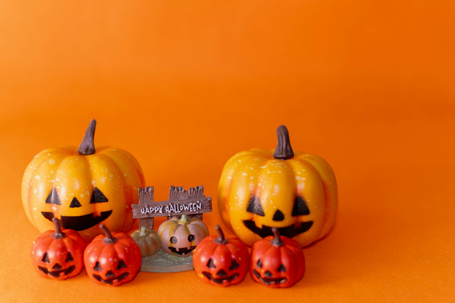 Jack-o'-lantern e piccole zucche su uno sfondo arancione