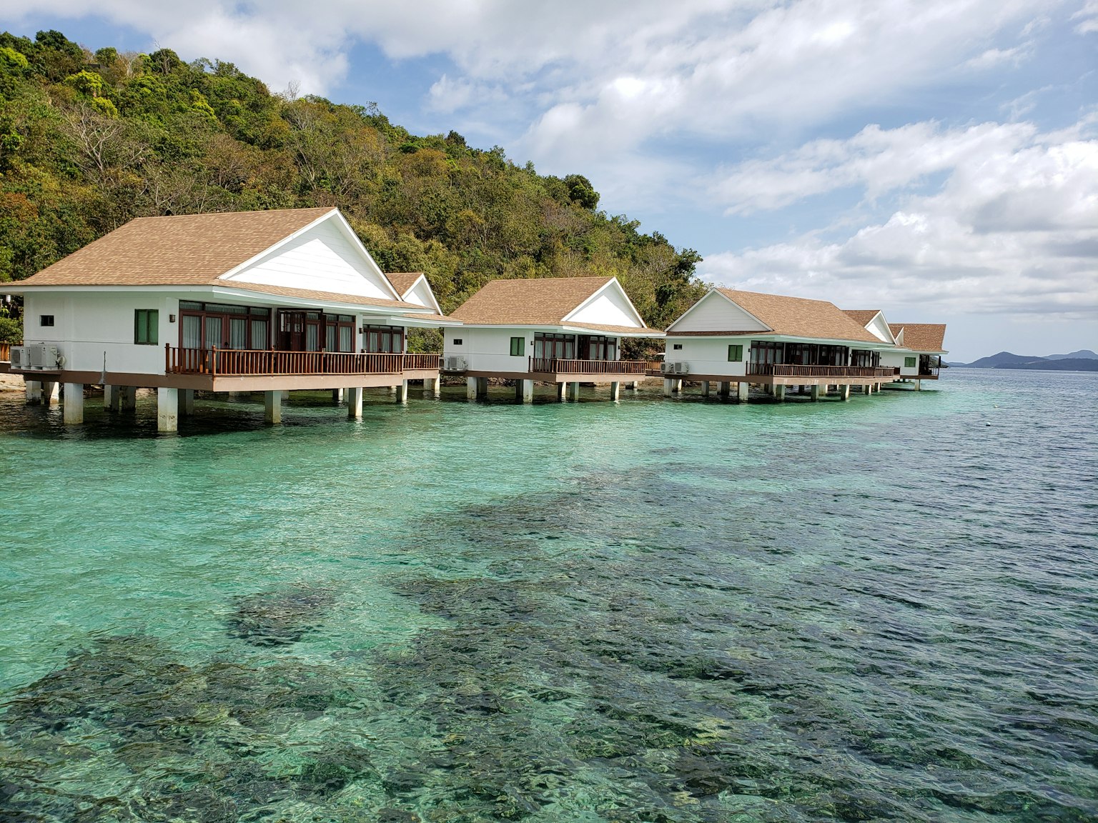 Bungalows sobre el agua en un agua turquesa rodeados de vegetación
