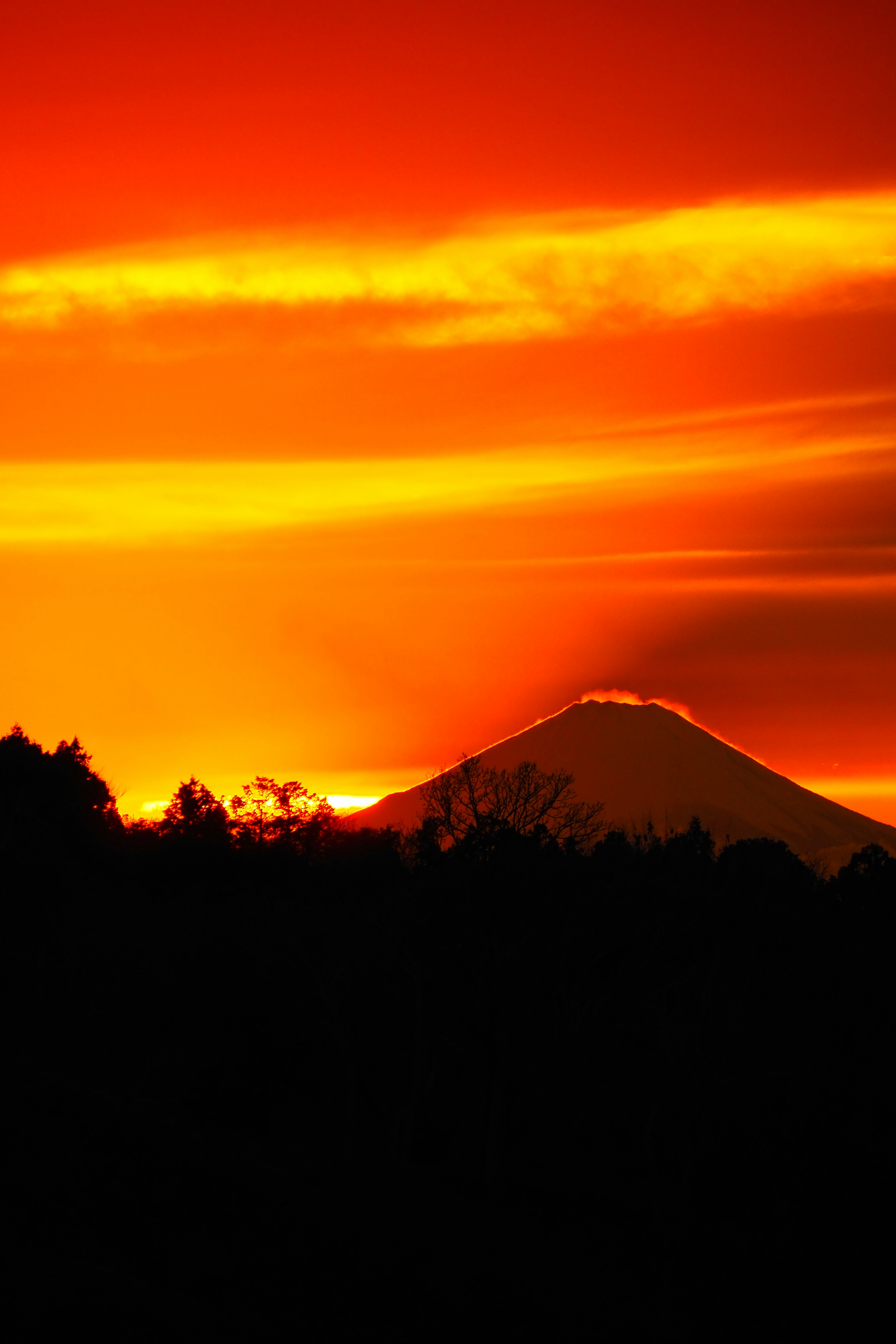 夕焼けの空とシルエットの山