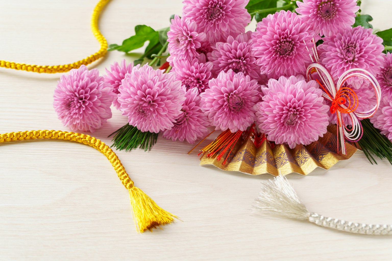 Bellissimo arrangiamento di crisantemi rosa e un ventaglio decorativo