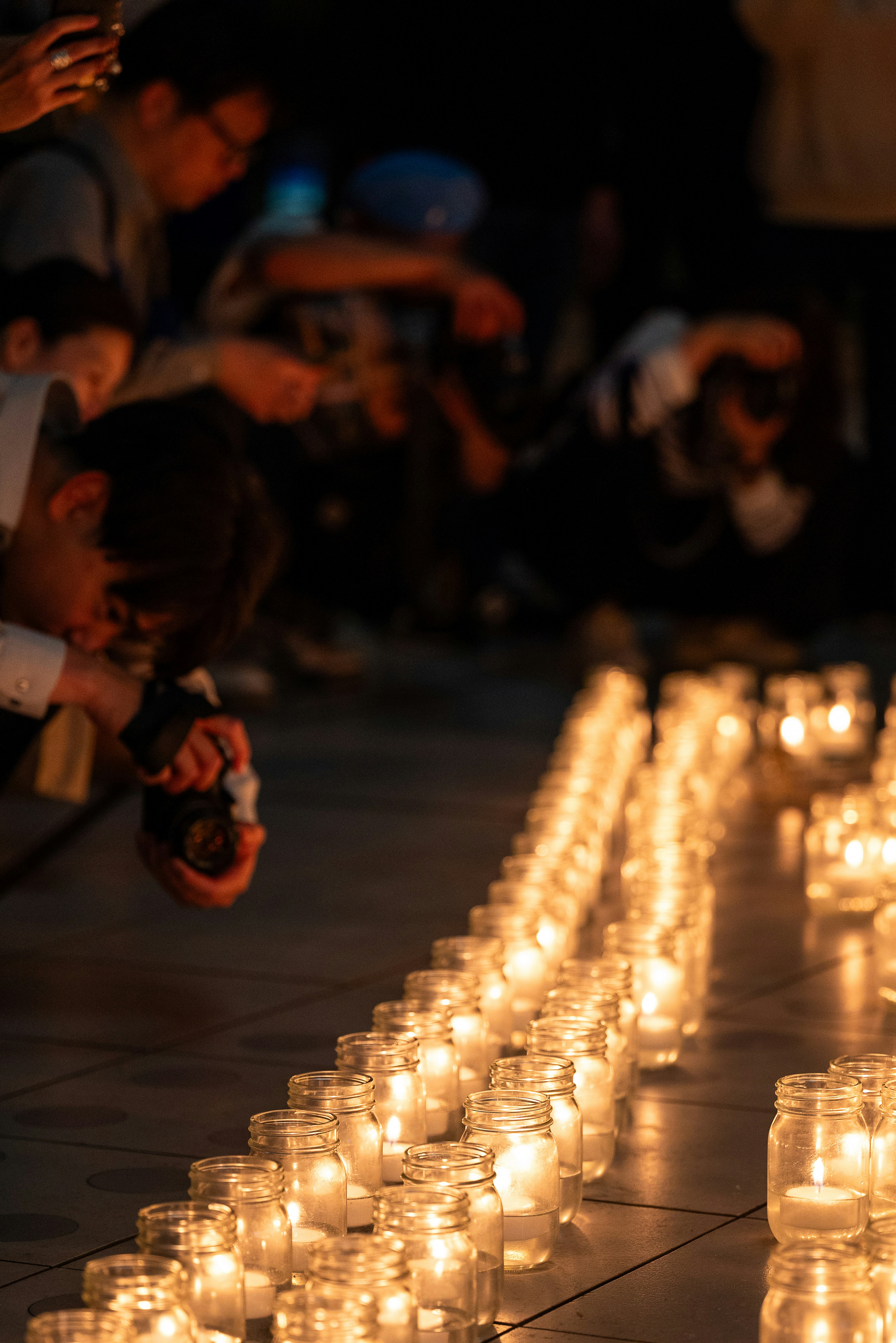 escena nocturna en la calle con profundidad y filas de velas