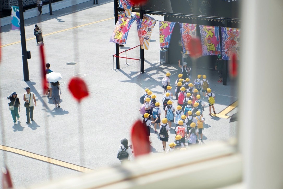 大阪万博2025の会場で色とりどりの旗と人の流れが見える通路