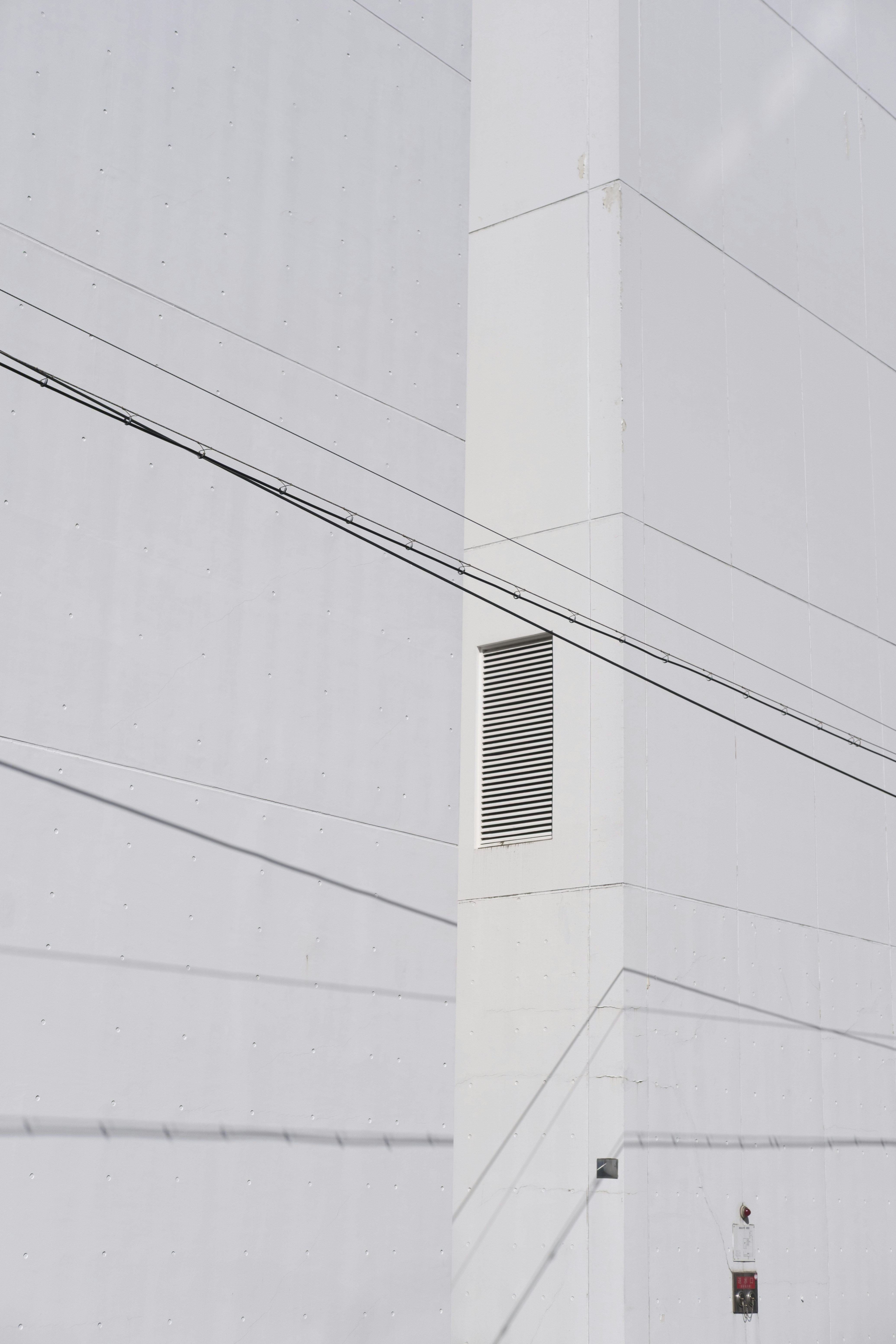 白い近代的な建物の外壁と配管のあるコーナー