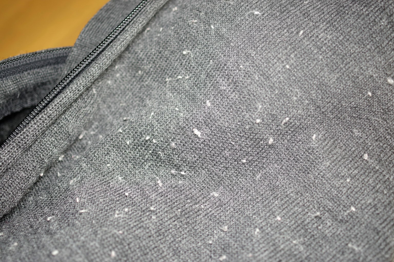 Close-up of gray fabric with white lint and fuzz