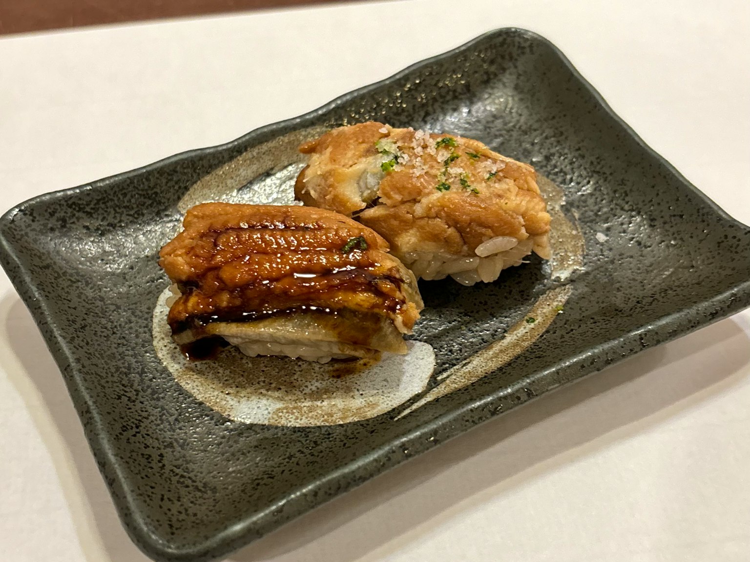 烤鳗鱼和白鱼寿司放在黑色盘子上