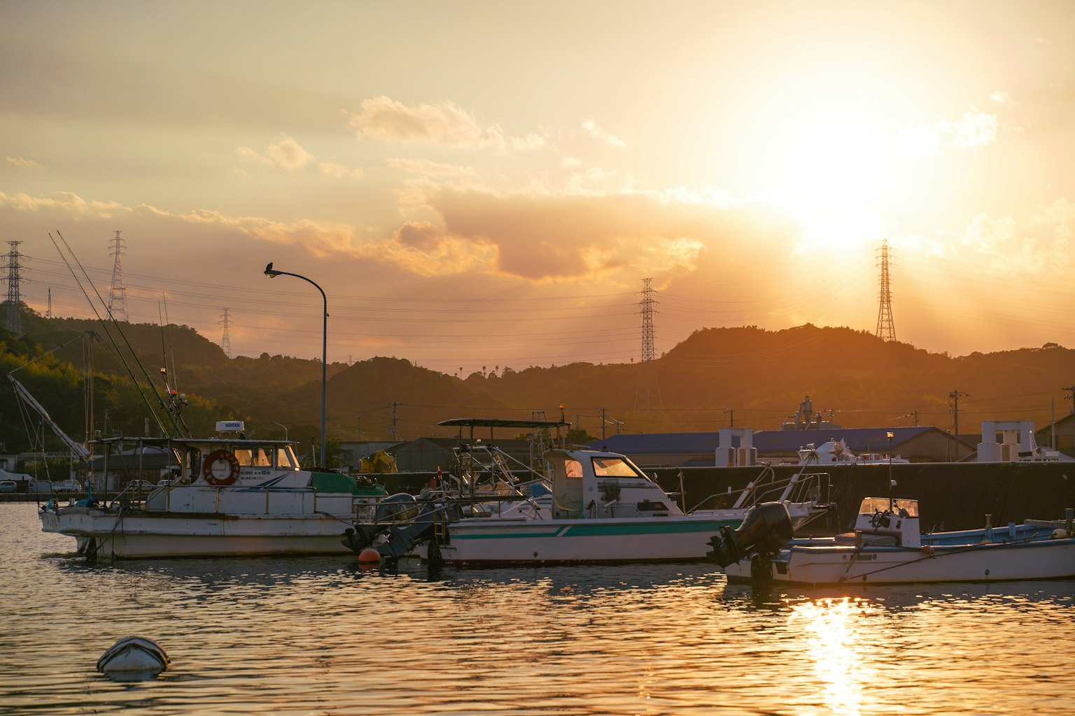 Hafenszene bei Sonnenuntergang mit Booten auf ruhigem Wasser und Lichtreflexionen