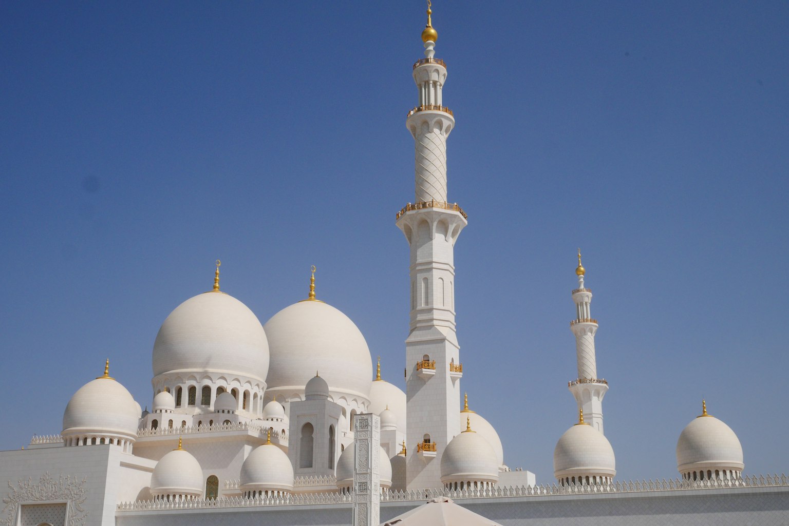 Vue extérieure d'une mosquée avec des dômes et des minarets blancs