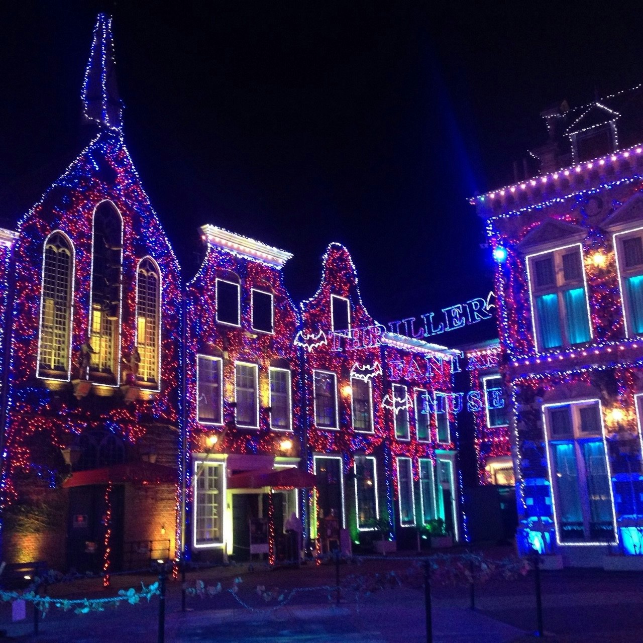 Façades de bâtiments illuminées la nuit dans une rue décorée