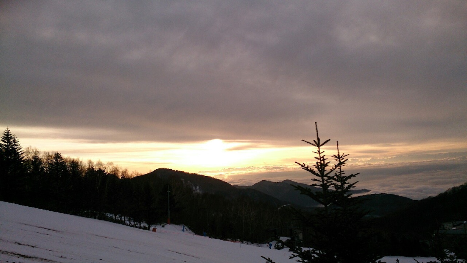 Montañas cubiertas de nieve con un cielo nublado al atardecer