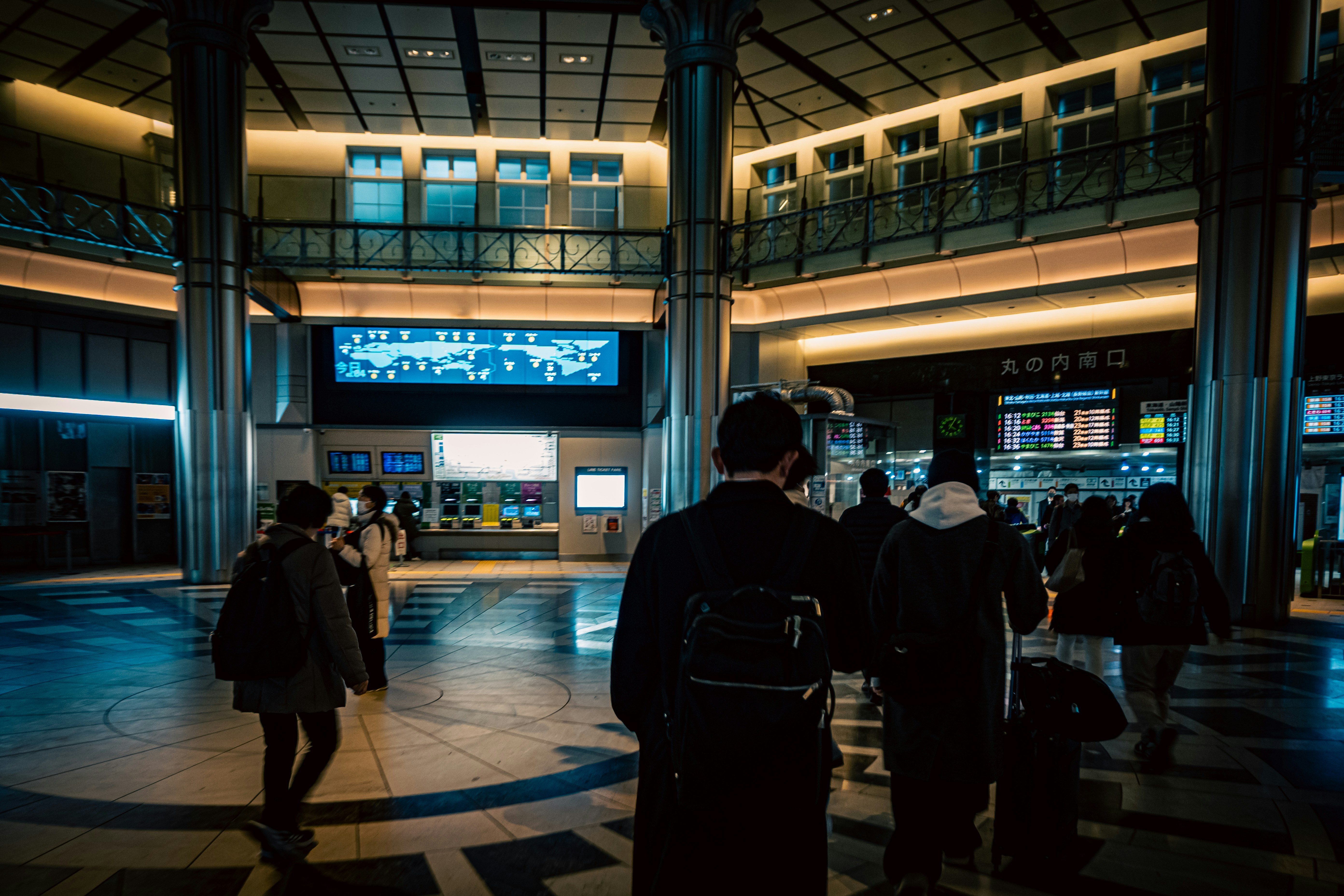 Corridoio di stazione con persone e display informativi luminosi