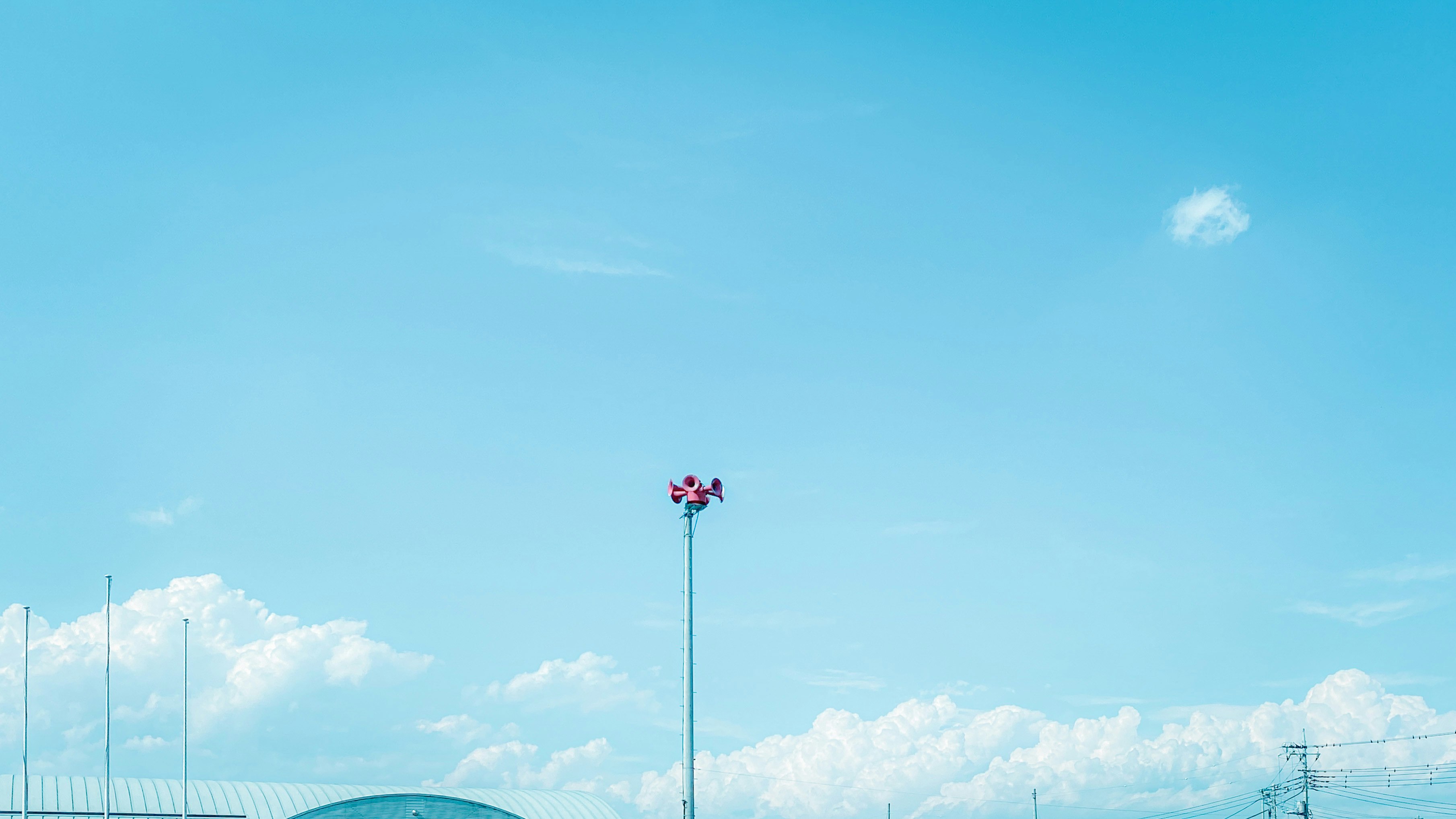 青空の下に立つ花の飾りのある街灯
