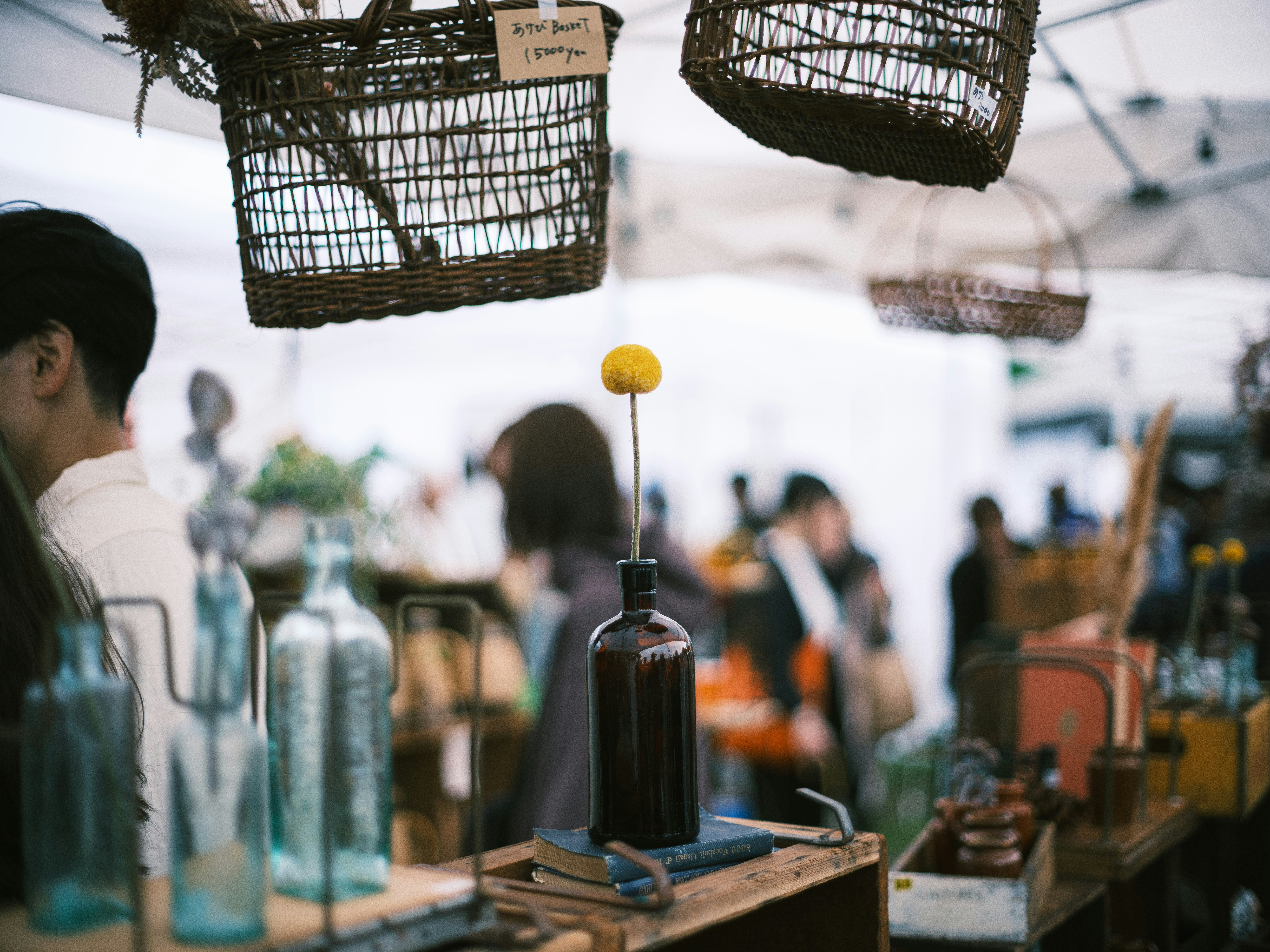Flaschen und Metallwerkzeuge aufgereiht an einem Stand auf dem Flohmarkt