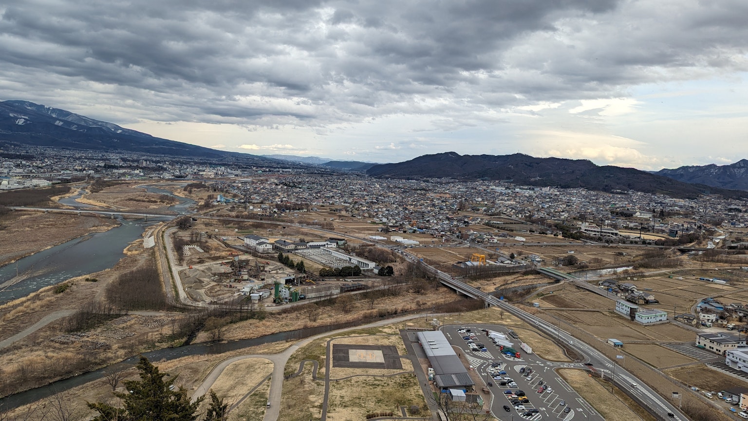 Vista panorámica de una ciudad y un río con montañas al fondo
