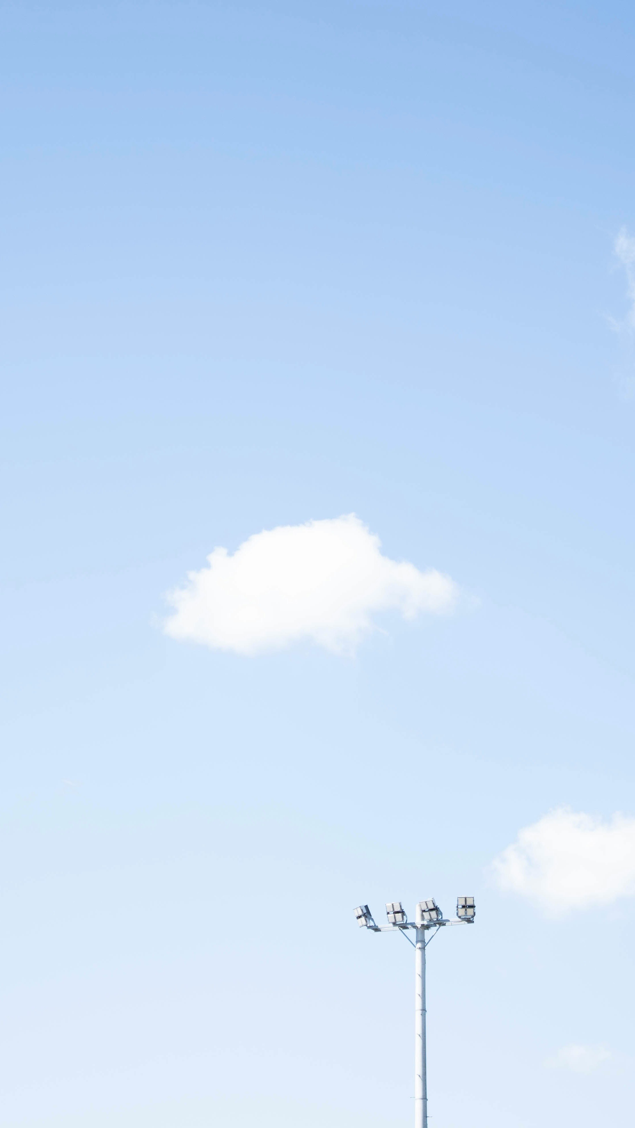 青空に浮かぶ雲と街灯のある空の風景