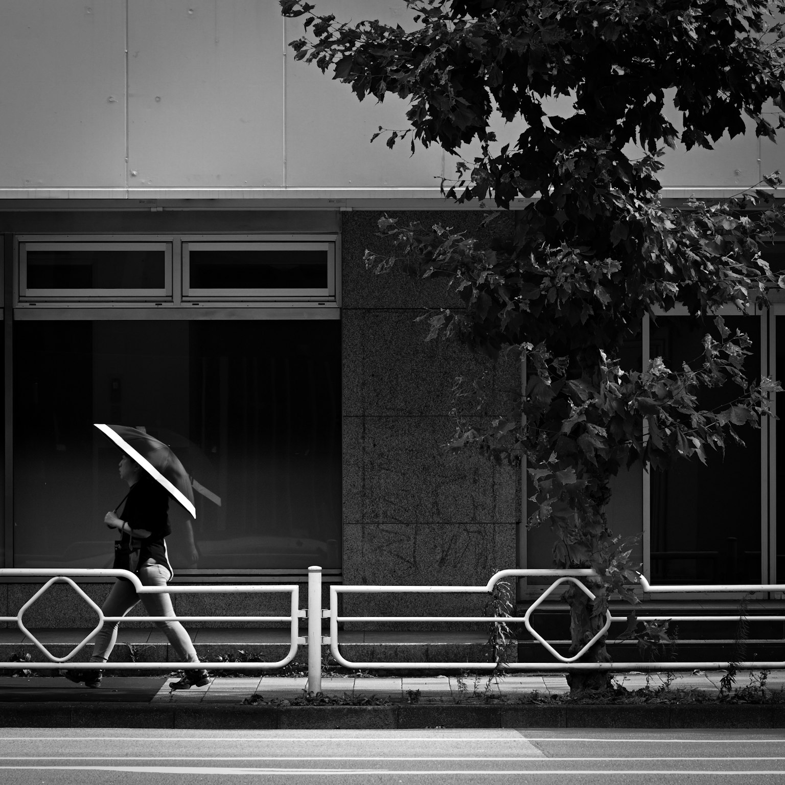 Donna che cammina con un ombrello in un contesto urbano