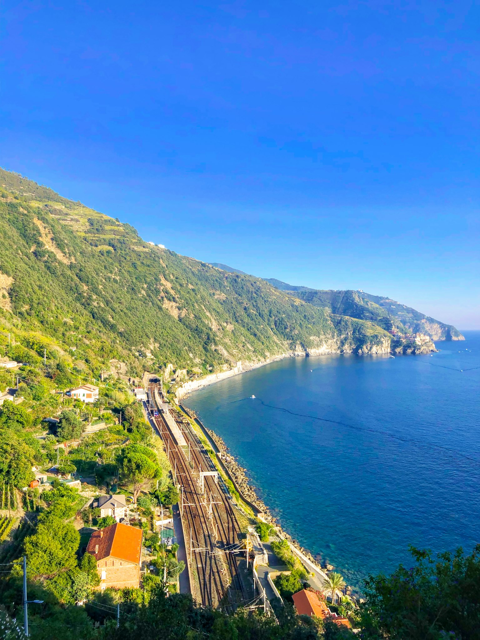 Scenic coastal view with mountains and railway along the shore