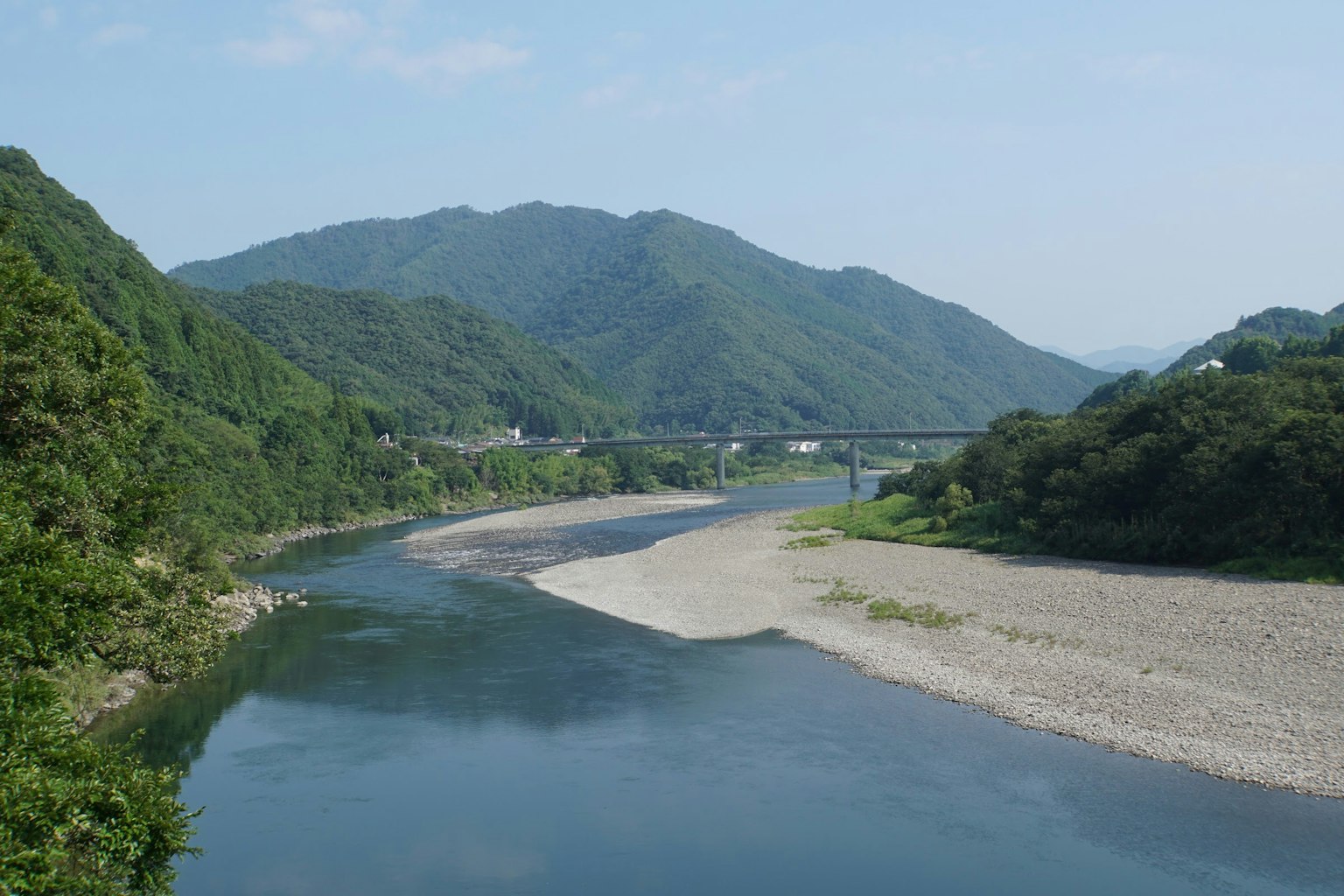Vue panoramique d'une rivière bleue serpentant à travers des montagnes vertes