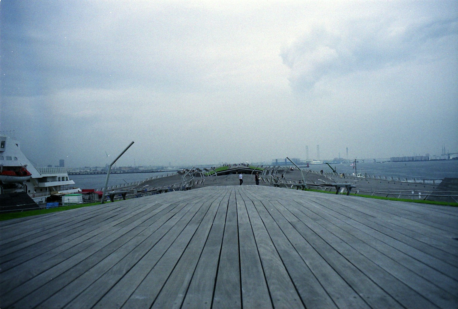 Large terrasse en bois sous un ciel nuageux sur une scène de port