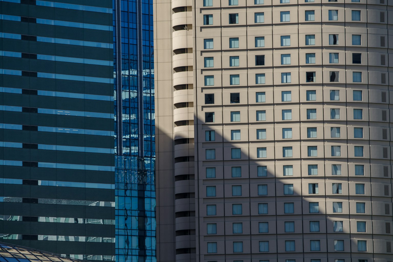 Nahaufnahme von Hochhausfassaden mit Schatten und Fensteranordnungen