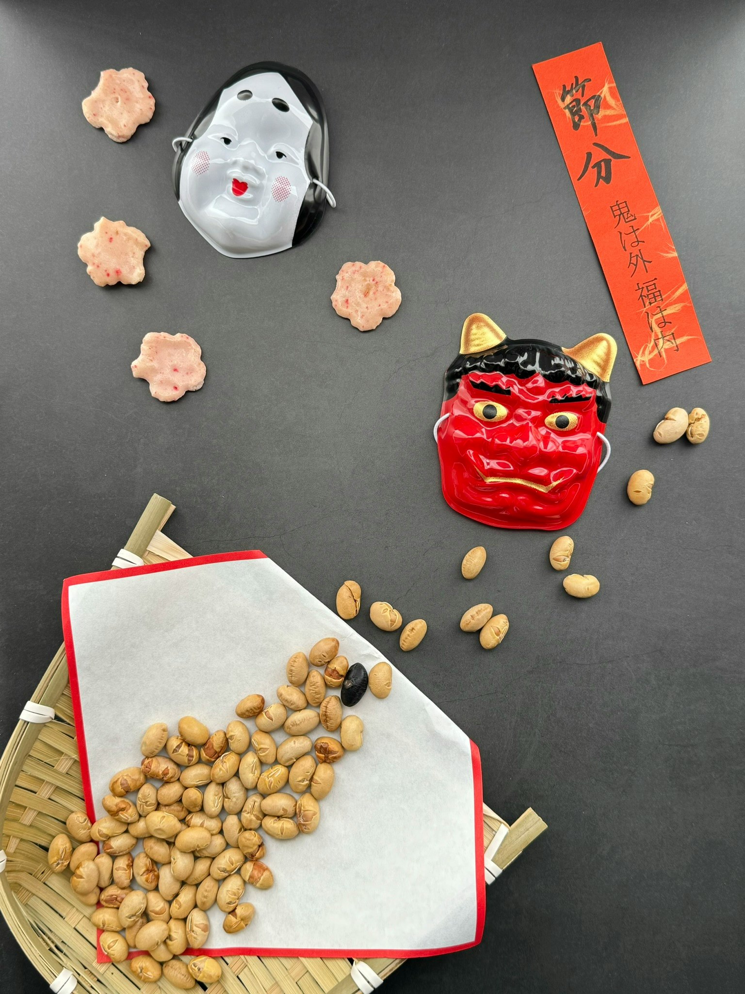 A black background scattered with beans and decorative masks