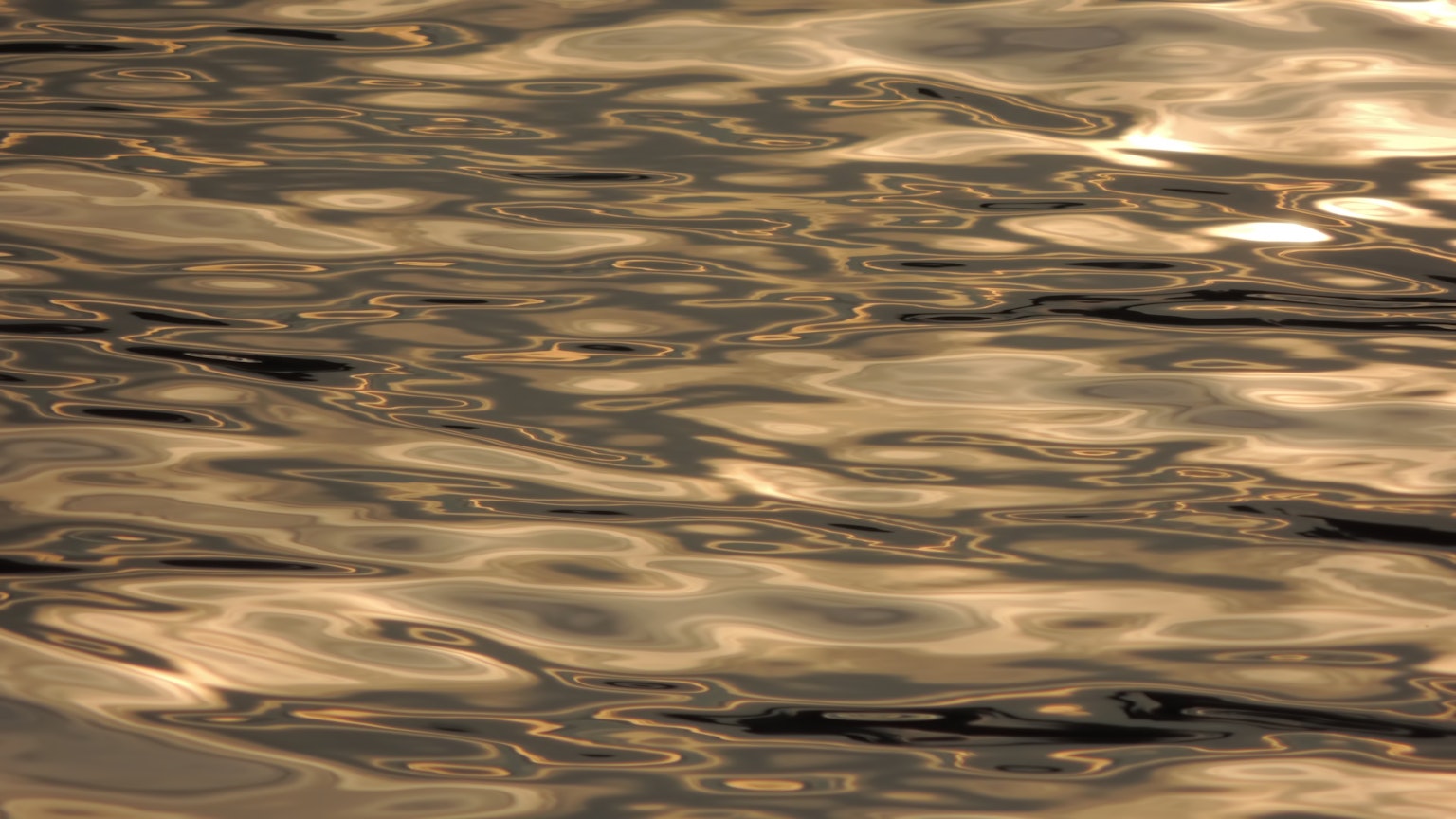 Superficie de agua dorada con ondas y reflejos de luz