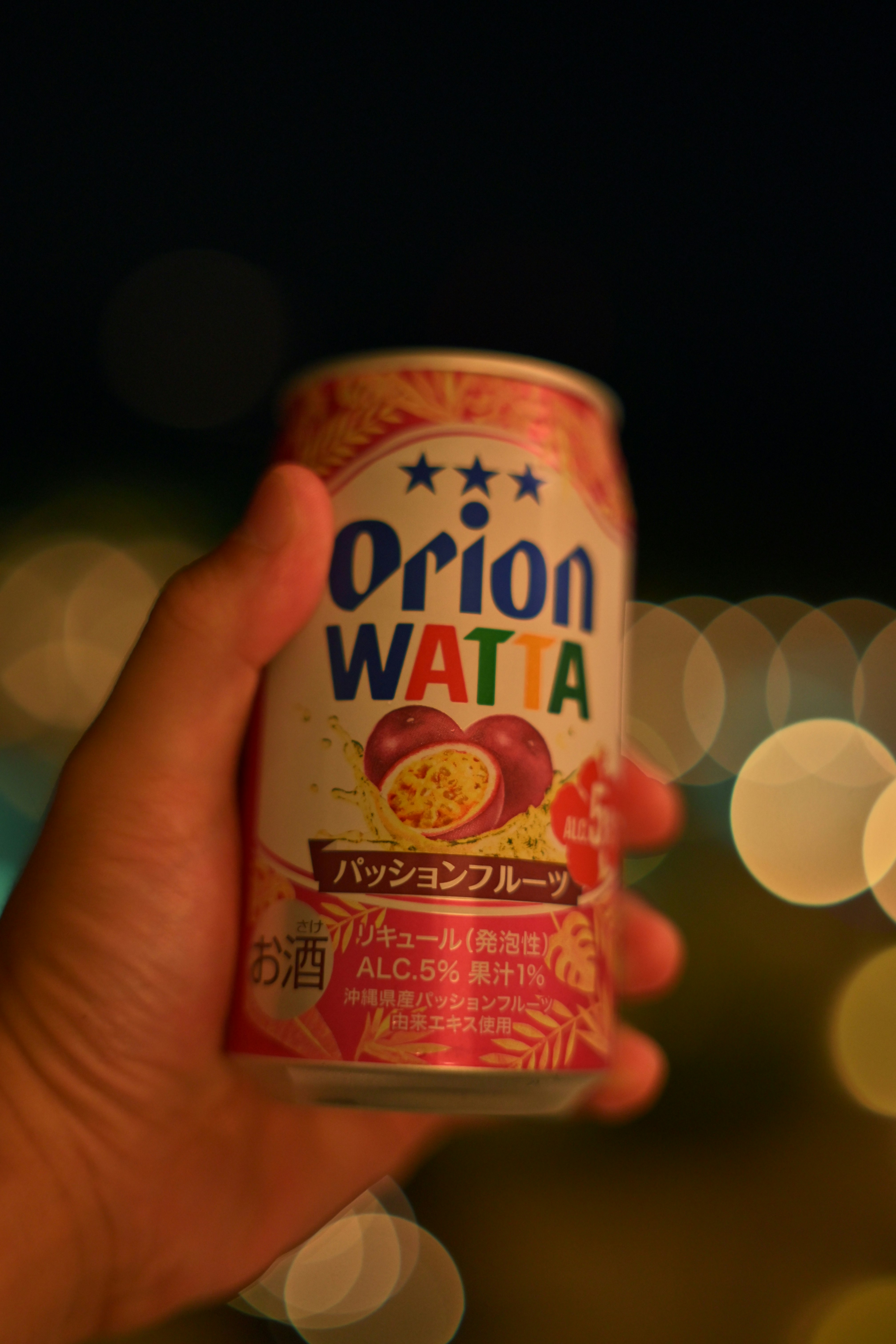 tay cầm đồ uống lon Orion WATTA với nền thành phố ban đêm mờ