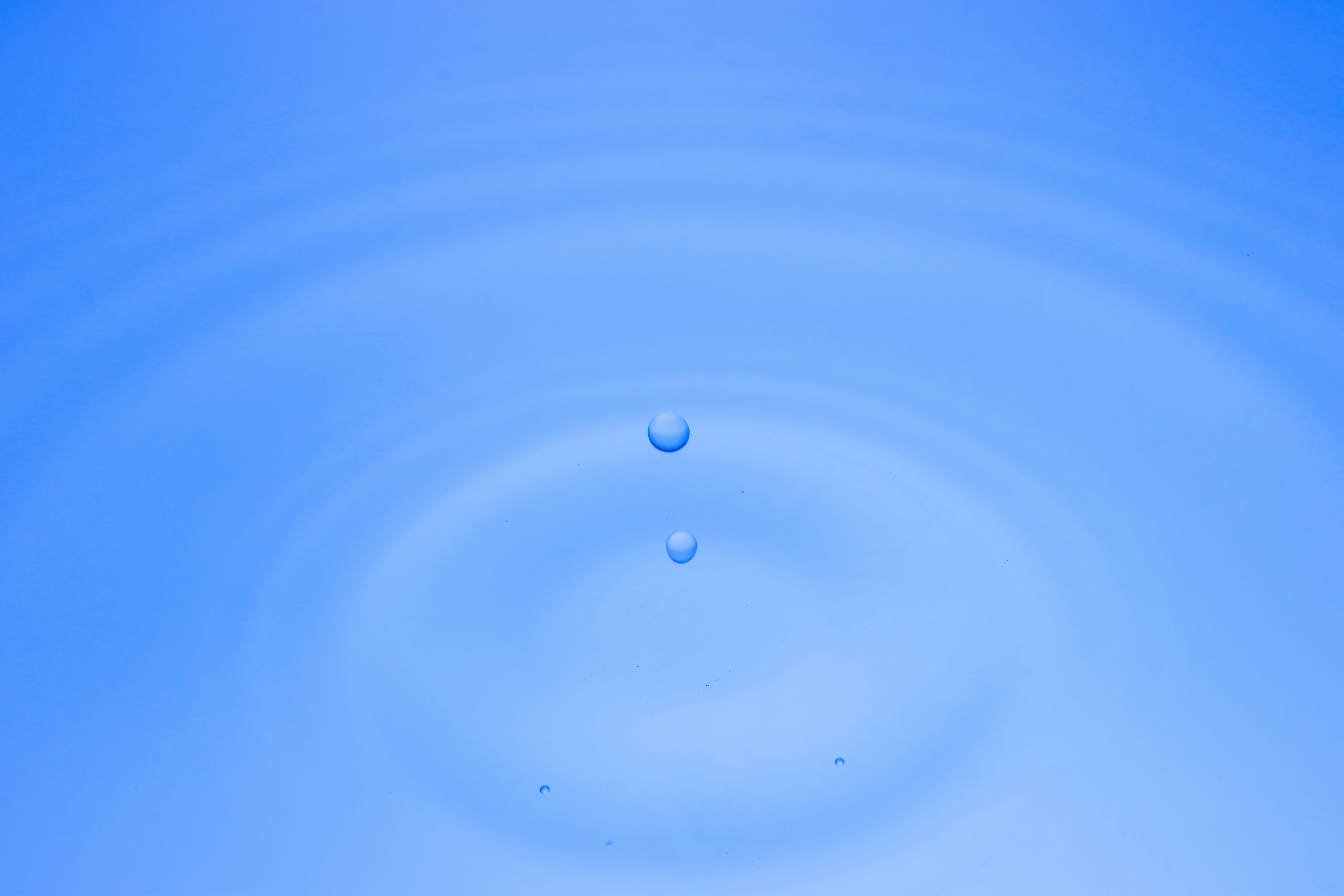 青い水面に浮かぶ水滴の波紋