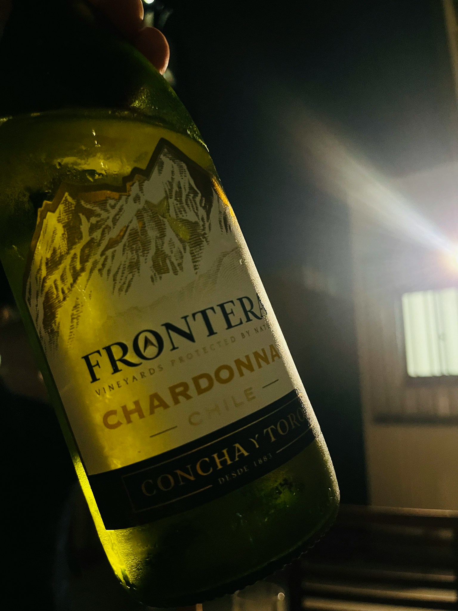 Frontera Chardonnay bottle illuminated in low light