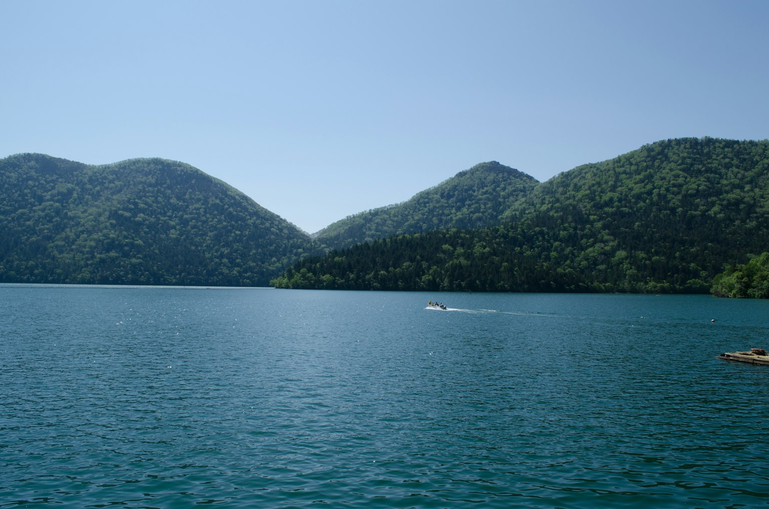 Vue panoramique d'un lac entouré de montagnes vertes