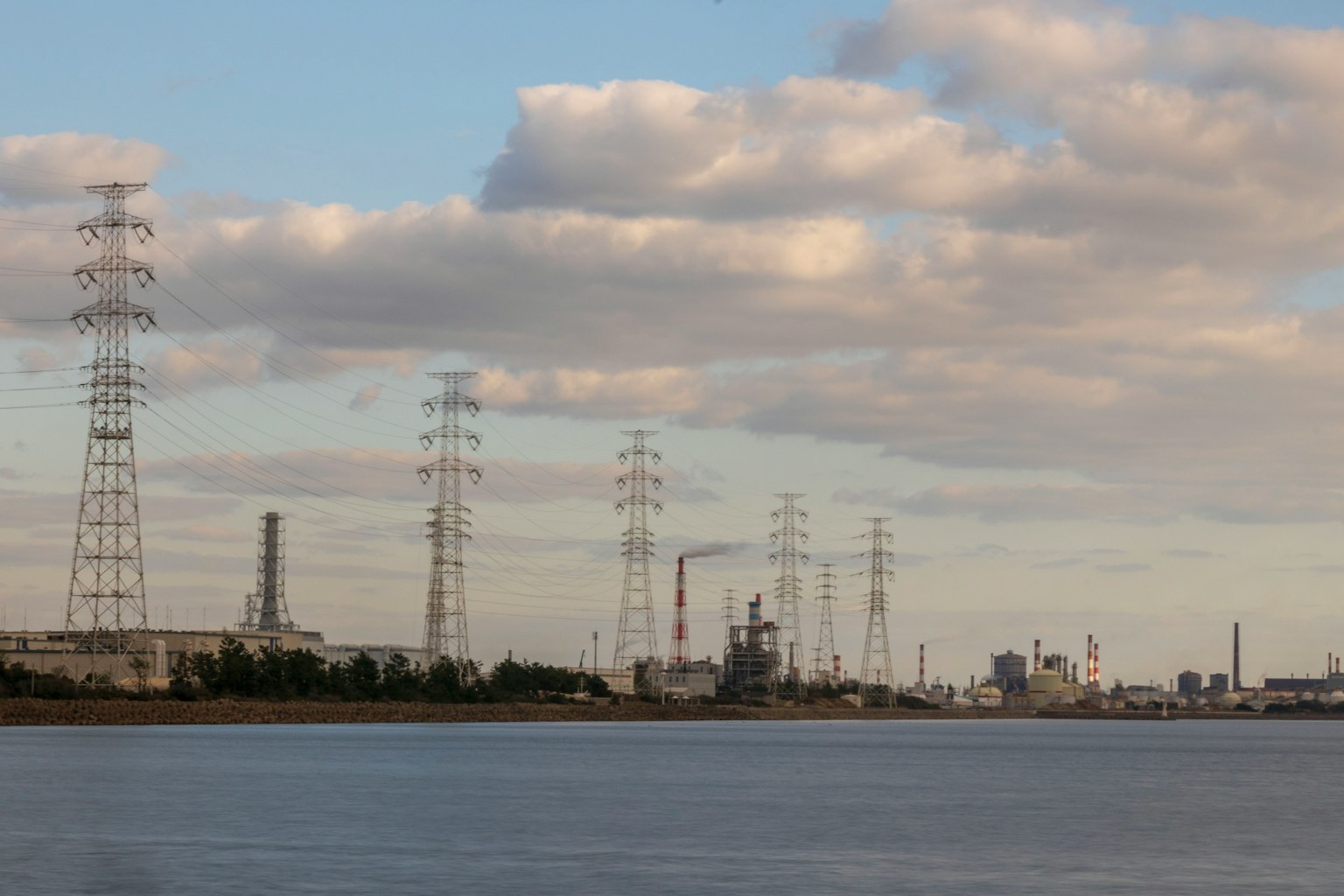Vista costiera con linee elettriche e edifici industriali