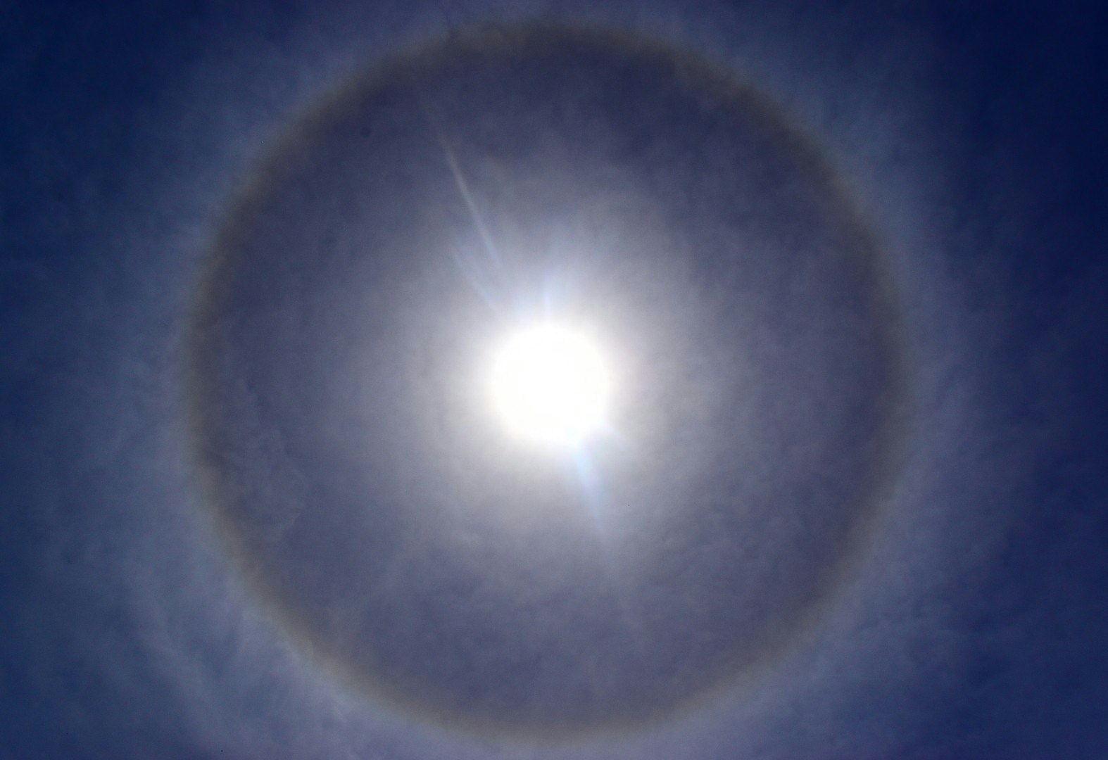 日暈のように見える太陽の輪が広がる空