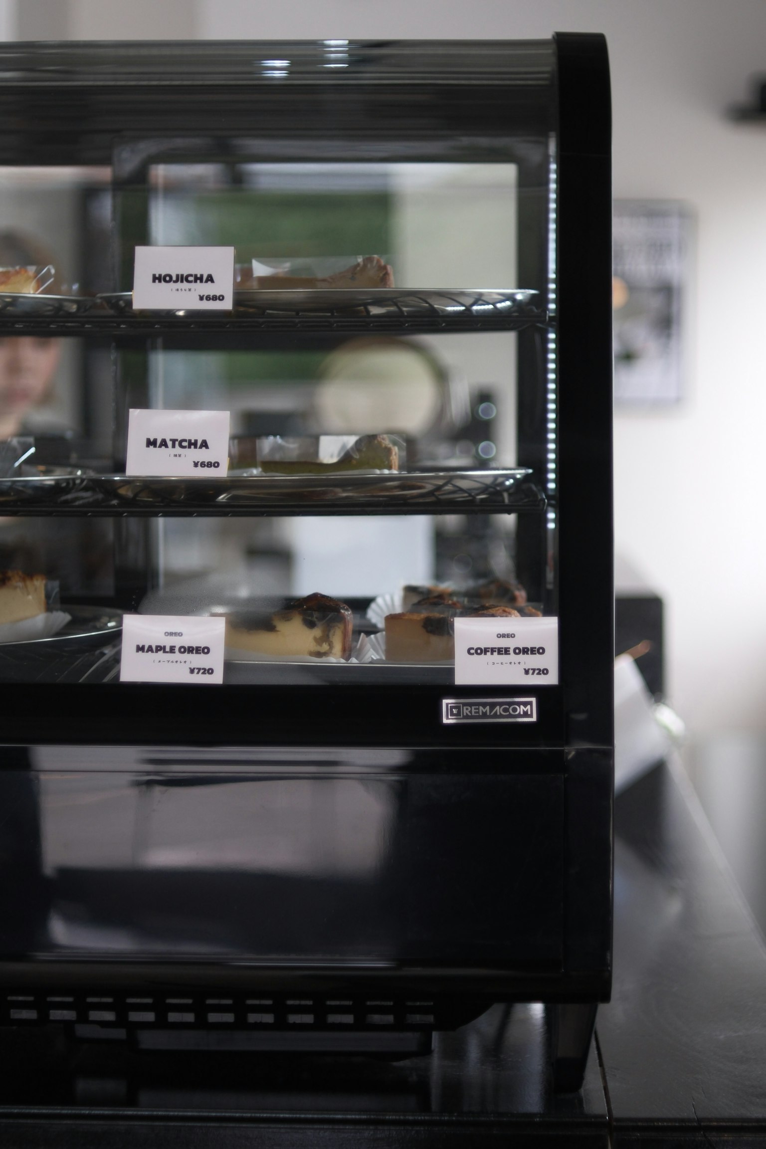 Etalase berisi berbagai makanan penutup yang diberi label dengan nama