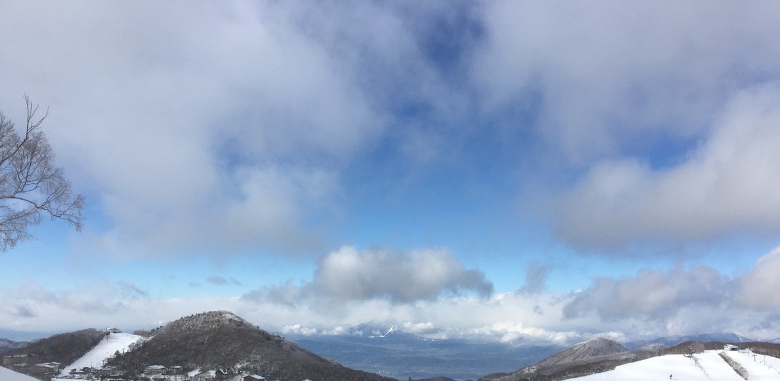 Montañas cubiertas de nieve bajo un cielo azul con nubes