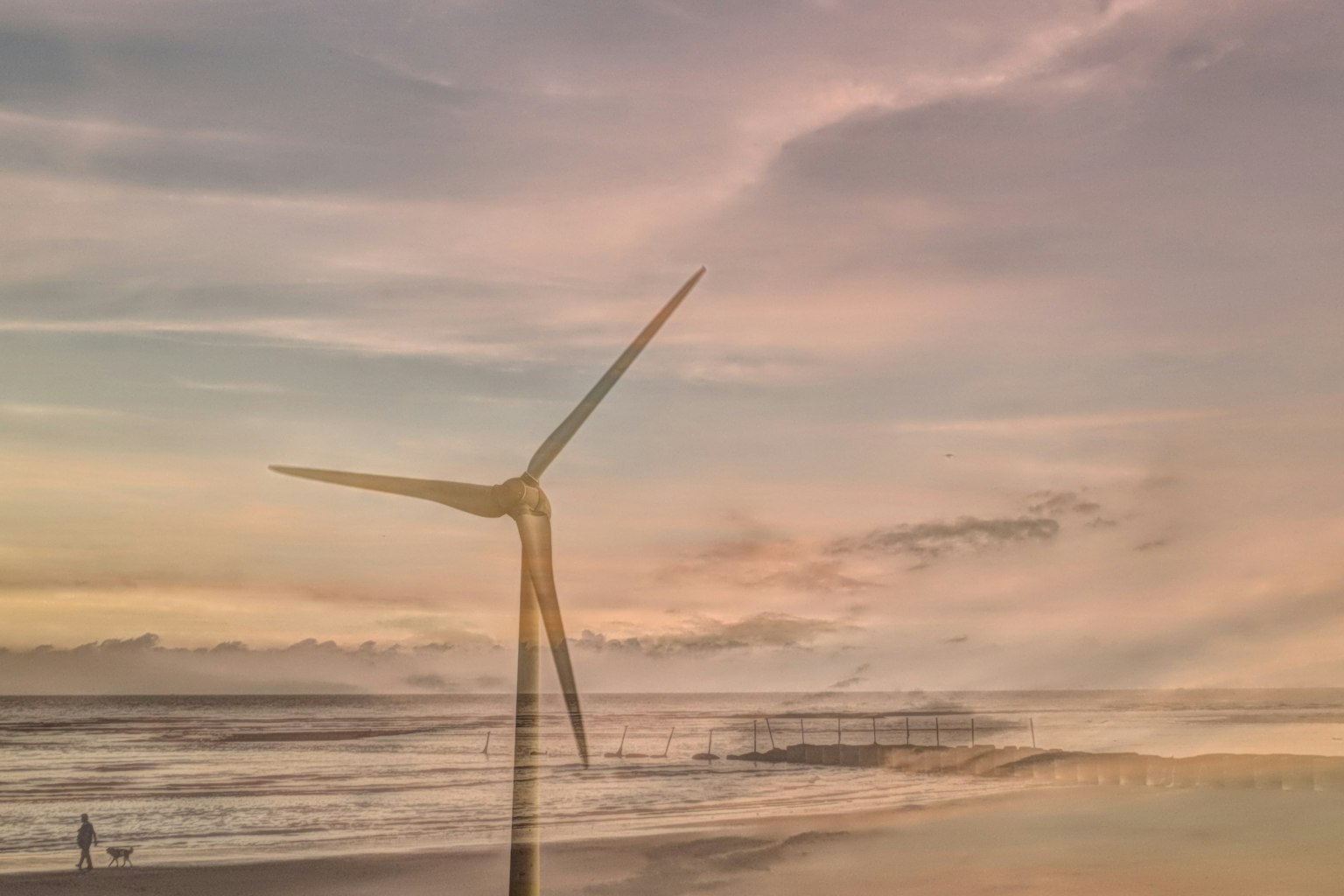 海岸に立つ風力発電機と美しい夕焼けの空