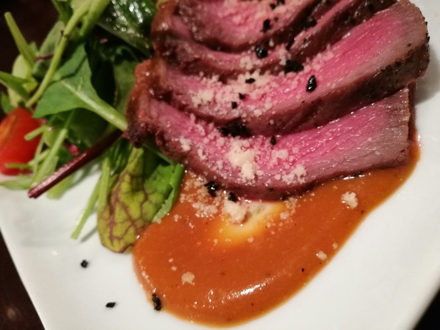 Thịt thái lát được phục vụ với salad và nước sốt trên đĩa