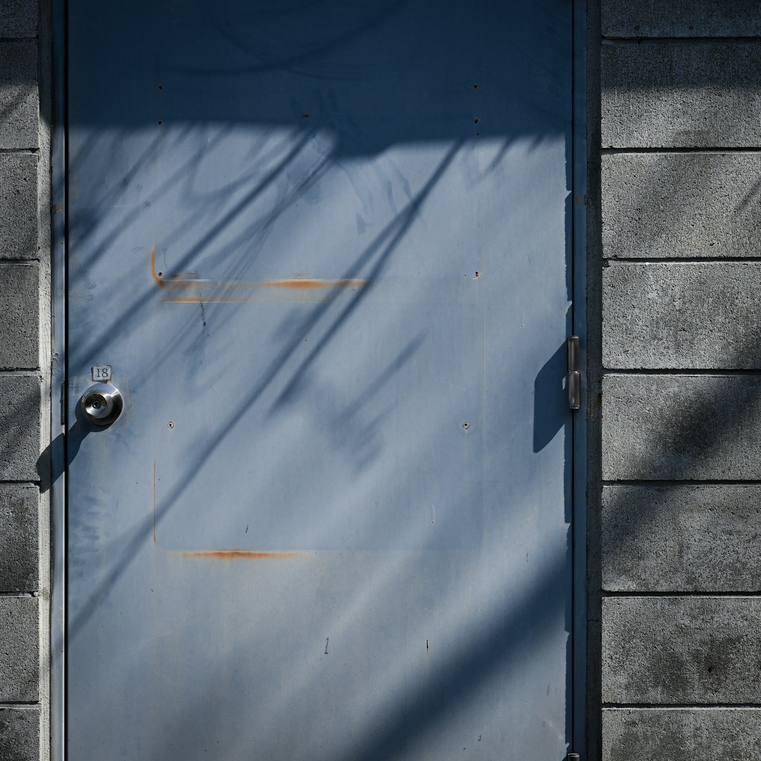 Puerta azul con sombras en la pared