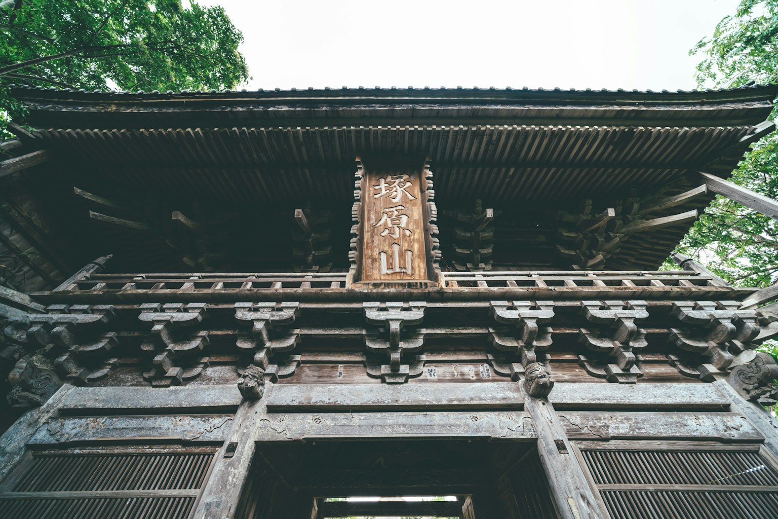 Vue d'en bas d'une porte en bois traditionnelle avec des sculptures ornées sur la structure supérieure