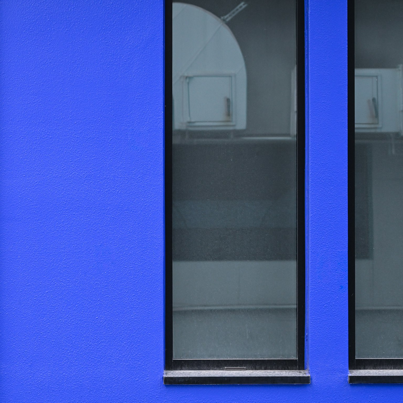 Simple design featuring two windows on a blue wall