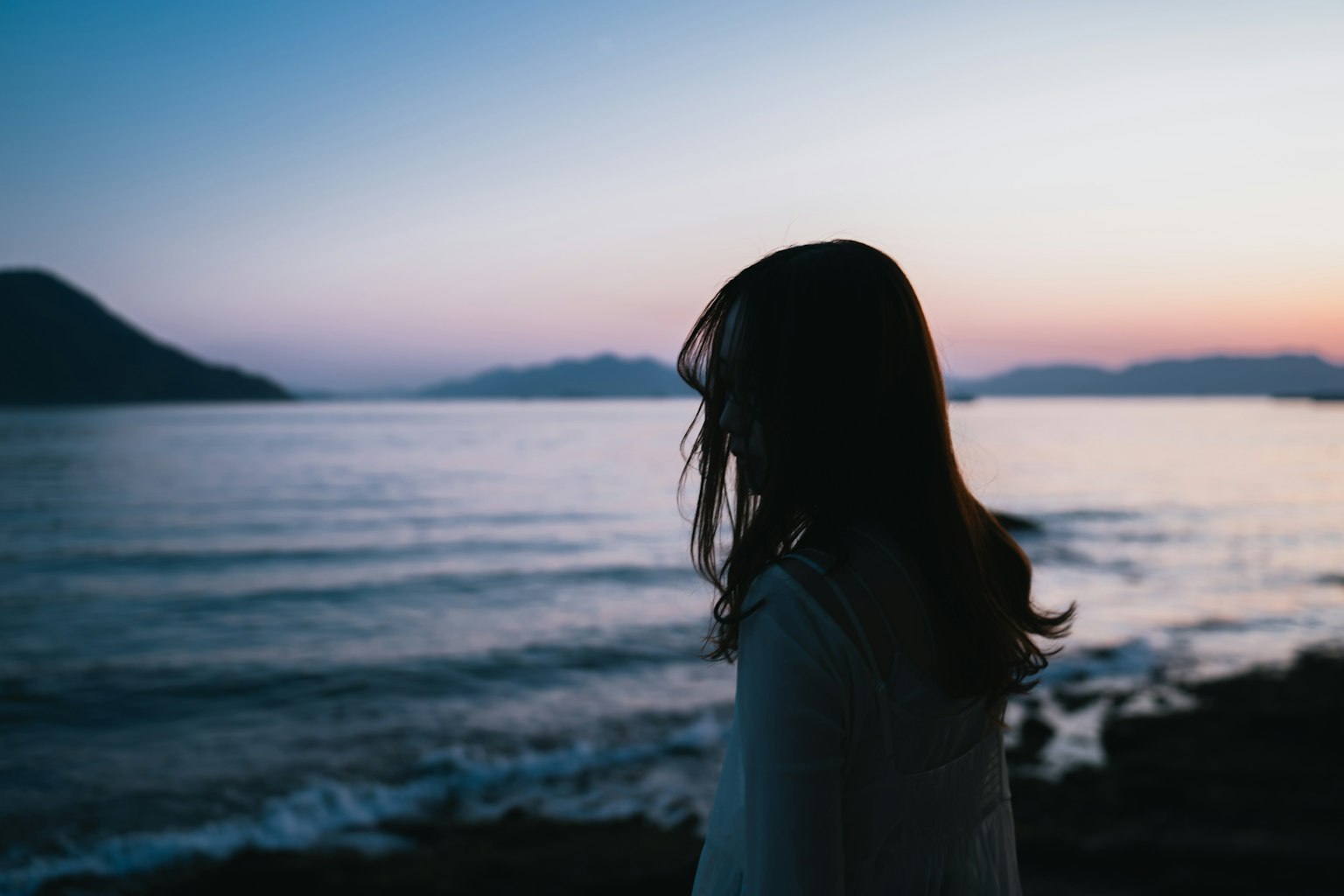 海邊凝視日落的女性輪廓