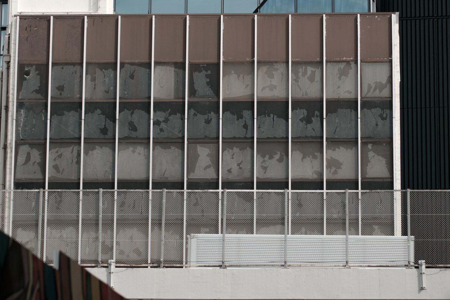 Facade of a building featuring vertical glass panels and structural supports
